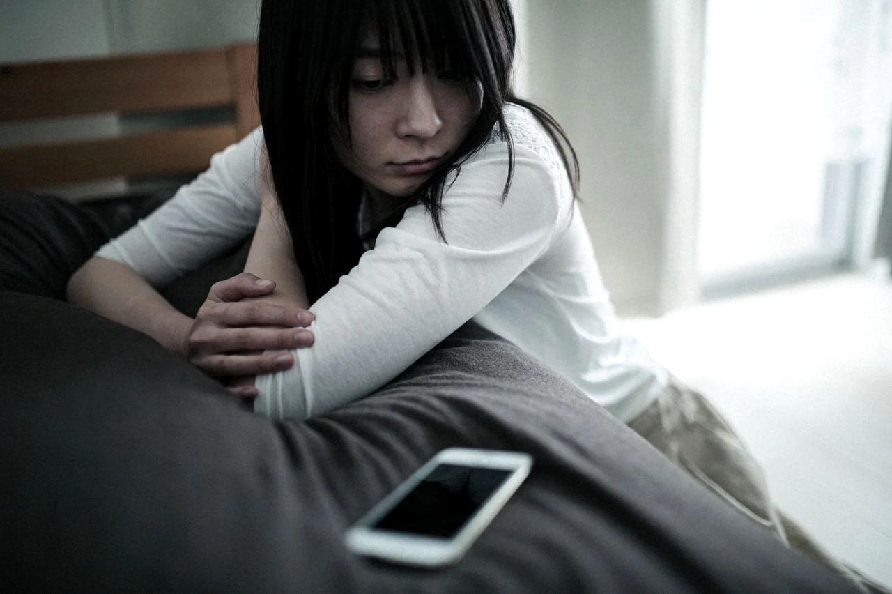 勤務先へ連絡するためスマホを操作する人