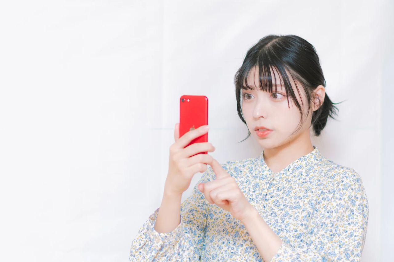60代の男性がスマートフォンでThreadsを操作しながら、副業の可能性について考えている様子