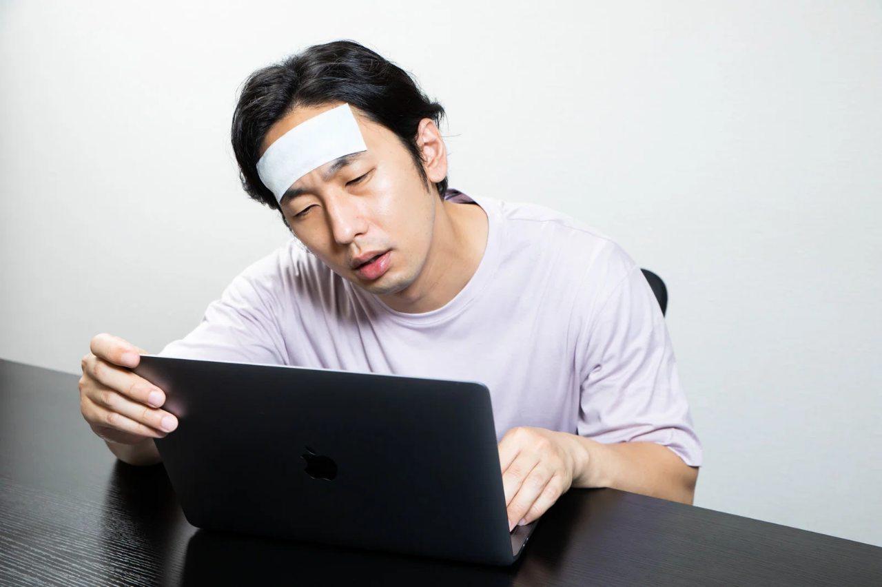 地方の静かなカフェで集中してノートパソコン作業をするコンサルタントの後ろ姿