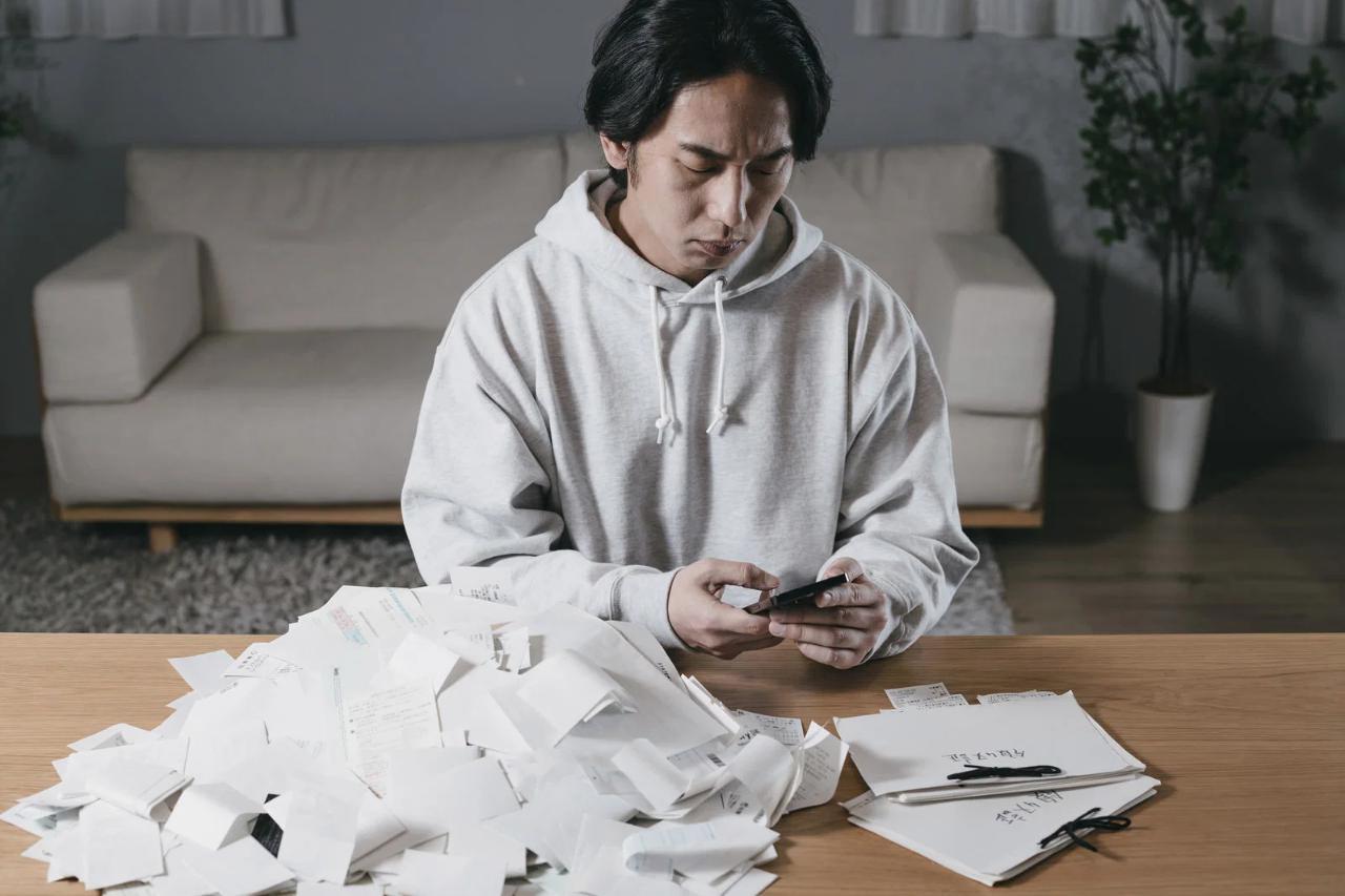 スマホを見て落胆する男性の手元、ポイ活の低効率に悩む様子
