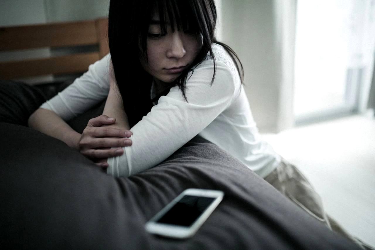ネットフリマの選び方に迷いながらスマートフォンを見つめる写真