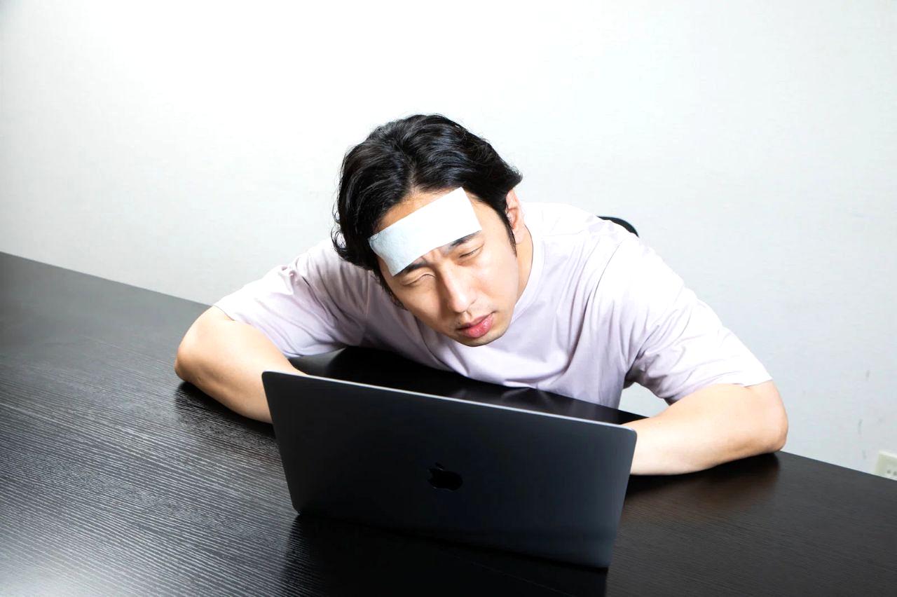 時計を横に置いて高速でキーボードを打つライターの手元の写真